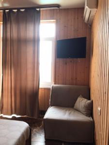 a living room with a couch and a window at Orhidea guest house in Gagra