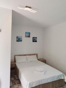1 dormitorio con cama blanca y techo blanco en Casa Andrei A, en Corbu