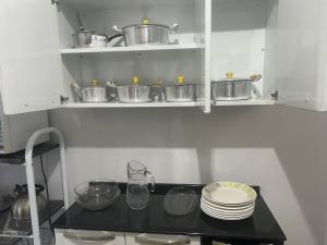 a small kitchen with pots and pans on shelves at CASA DE FÉRIAS II in Barra do Garças +7 photos