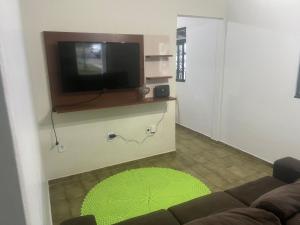 uma sala de estar com um sofá e uma televisão de ecrã plano em CASA DE FÉRIAS II em Barra do Garças