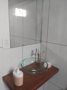 een badkamer met een glazen wastafel en een spiegel bij Chalés Pedacinho do Céu entre Penedo e Visconde de Mauá in Resende