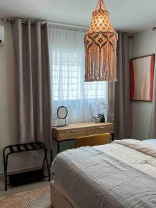 a bedroom with a desk and a bed and a chandelier at Modern luxurious apartment in Santiago de los Caballeros