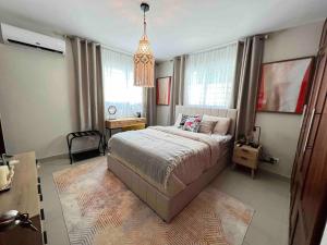 a bedroom with a large bed and a chandelier at Modern luxurious apartment in Santiago de los Caballeros