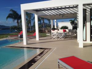 a pavilion with a pool and a table and chairs at Zenith Nevis in Nevis