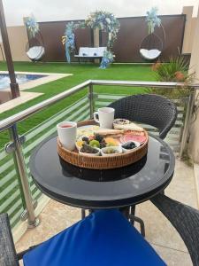 a tray of food on a table with two cups at Blue Revan chalet in Salalah