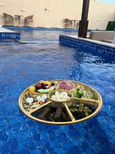 una bandeja de comida en la piscina en Blue Revan chalet, en Salalah