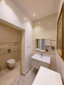 a bathroom with a white toilet and a sink at بيت النرجس الخاص in Riyadh