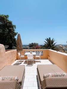 Un patio con sillas y una mesa en el balcón. en Joy Beach Ηotel, en Perivolos