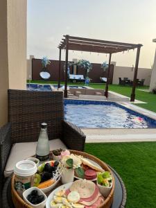una bandeja de comida en una mesa junto a una piscina en Blue Revan chalet, en Salalah