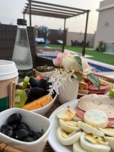 a table with plates of food and bowls of fruit at Blue Revan chalet in Salalah +8 photos