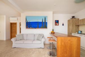 a living room with a white couch and a kitchen at Villa Fora Hvar in Hvar