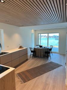 a kitchen and dining room with a table and chairs at The Modern Fisherman Cabin Lofoten in Ballstad