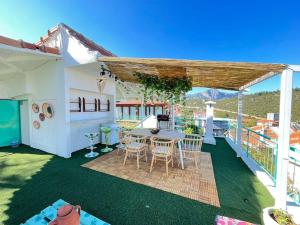 un patio con mesa y sillas en una terraza en Villa with swiming pool 360 see view, en Geyikbayırı