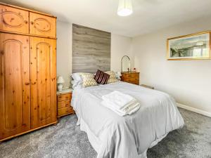 a bedroom with a large bed and a wooden cabinet at Buxton Holiday Home in Buxton