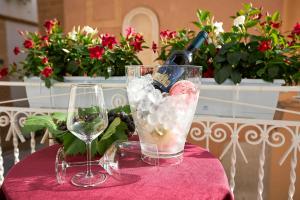 Una botella de vino y dos copas en una mesa. en Arbarìa, en Marsala