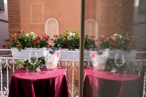 dos mesas con copas de vino y flores. en Arbarìa, en Marsala