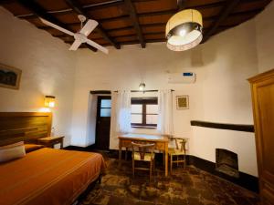 een slaapkamer met een bed, een bureau en een tafel bij La Casona de Moldes in Coronel Moldes