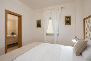 a white bedroom with a bed and a bathroom at Villa Fora Hvar in Hvar +78 photos
