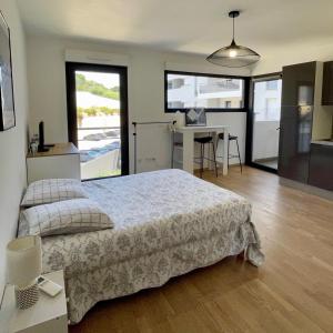 a bedroom with a large bed and a desk with a computer at Parking gratuit grande terrasse Proche Centre Ville in Ajaccio