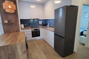 a kitchen with a refrigerator and a table in it at Salona Garden Apartman in Solin