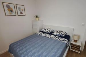 a bedroom with a blue bed with pillows on it at Salona Garden Apartman in Solin