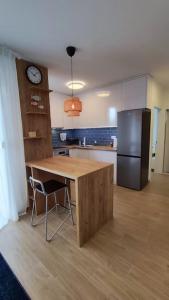 a kitchen with a wooden table and a refrigerator at Salona Garden Apartman in Solin