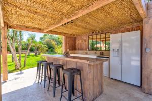 an outdoor kitchen with a large island with bar stools at Villa CARIOCA St Tropez in Saint-Tropez