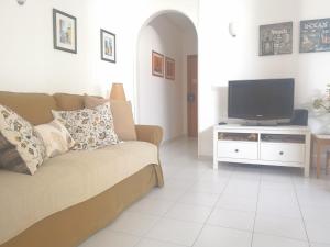 a living room with a couch and a flat screen tv at Caparica Lounge & Terrace in Costa da Caparica