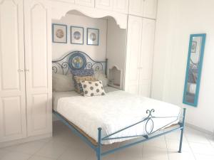 a white bedroom with a bed with a blue frame at Caparica Lounge & Terrace in Costa da Caparica