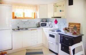 a kitchen with white cabinets and a stove top oven at Stunning Home In Gunnarskog With Kitchen in Gunnarskog