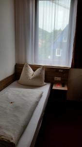 Bett in einem Zimmer mit einem großen Fenster in der Unterkunft Hotel Alte Krone in Tübingen