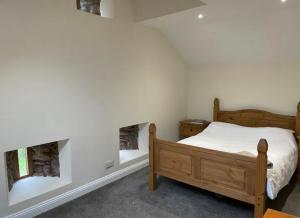 Tempat tidur dalam kamar di “Dews Barn” acer field retreat
