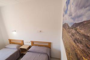 two beds in a room with a painting on the wall at Turó de L´Home in Santa María de Palautordera
