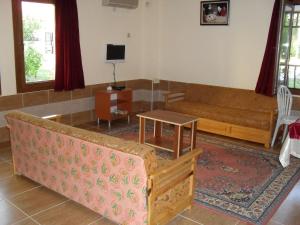 ein Wohnzimmer mit einem Sofa und einem Tisch in der Unterkunft Villa Ozalp Apartments in Dalyan