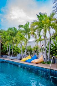 a swimming pool with palm trees and colorful pillows at Mantra Pattaya Pool Villa-Pool with Jacuzzi in Pattaya-Pet-Friendly in Jomtien Beach