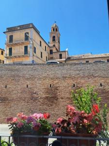 a brick wall with flowers in front of a building at CINQUE TORRI AFFITTACAMERE in Osimo +21 photos