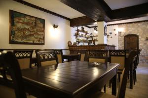 een eetkamer met een houten tafel en stoelen bij Hotel Vila Aleksander in Berat