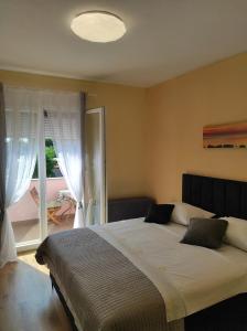 sypialnia z dużym łóżkiem i dużym oknem w obiekcie Apartments Zaton Draga w mieście Zaton