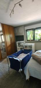 - une chambre avec un lit bleu dans l'établissement Schöne Ferienwohnung mit Terrasse und Garten, à Überherrn
