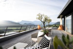 a balcony with furniture and a view of the mountains at Designhotel Gius La Residenza in Caldaro