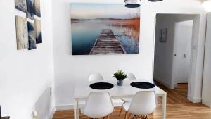 un comedor blanco con mesa y sillas en Apartamento renovado y tranquilo, ideal familias - los mejores accesos, en Málaga