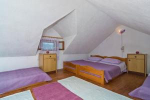 - une chambre mansardée avec 2 lits et des draps violets dans l'établissement Vacation House, PARKING INCLUDED, Lovrecina, à Postira