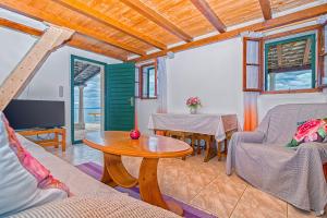 a living room with a table and a tv at Vacation House, PARKING INCLUDED, Lovrecina in Postira