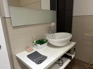 ein Badezimmer mit einem weißen Waschbecken und einem Spiegel in der Unterkunft Il nido in centro in Rovereto