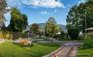 een park met een speeltuin met bomen en gras bij Appartements D'Angelo in Bodensdorf
