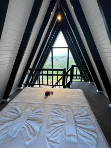 a bed in a room with a large window at Kazdağları Sağlıklı Yaşam Köyü in Edremit