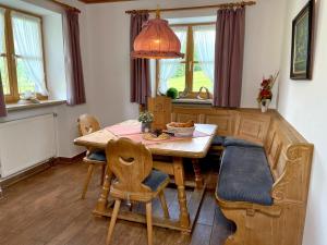 a dining room with a wooden table and chairs at Pension Loiplstüberl in Bischofswiesen