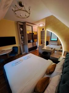 a bedroom with a large white bed and a couch at Lakeside Apartment in Palić