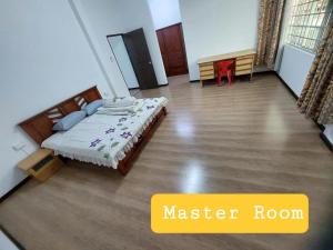 a bedroom with a master room with a bed and a table at Sibu wawasan no.1 Homestay in Sibu
