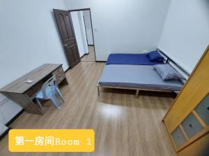 um pequeno quarto com uma cama e uma mesa em Sibu wawasan no.1 Homestay em Sibu